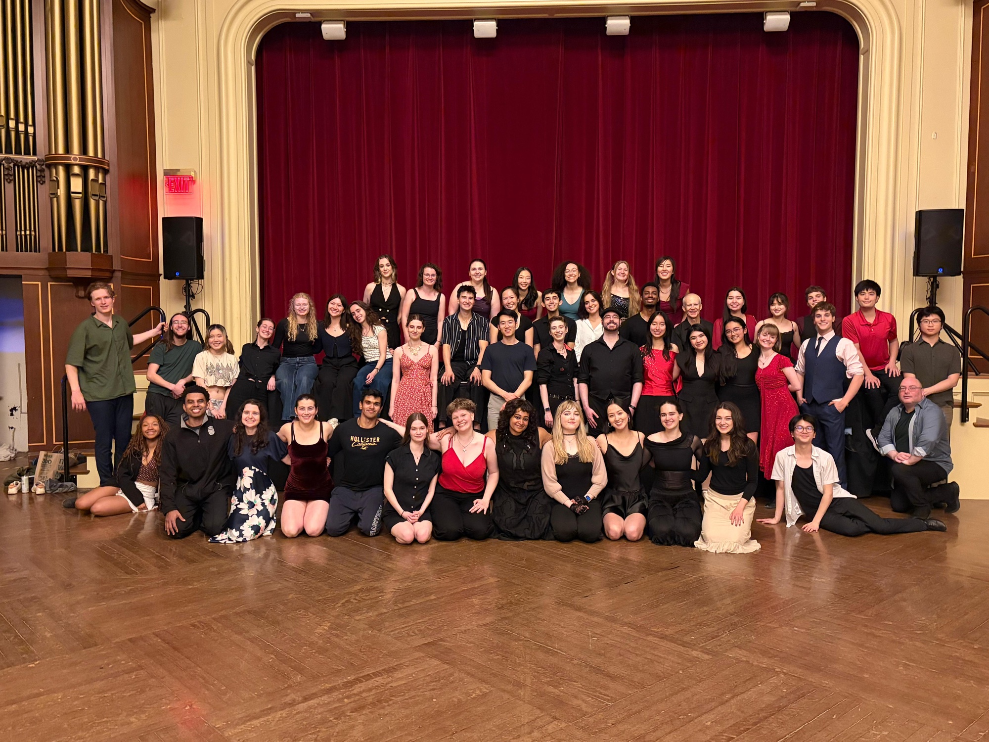 The whole team together in front of the red curtain.